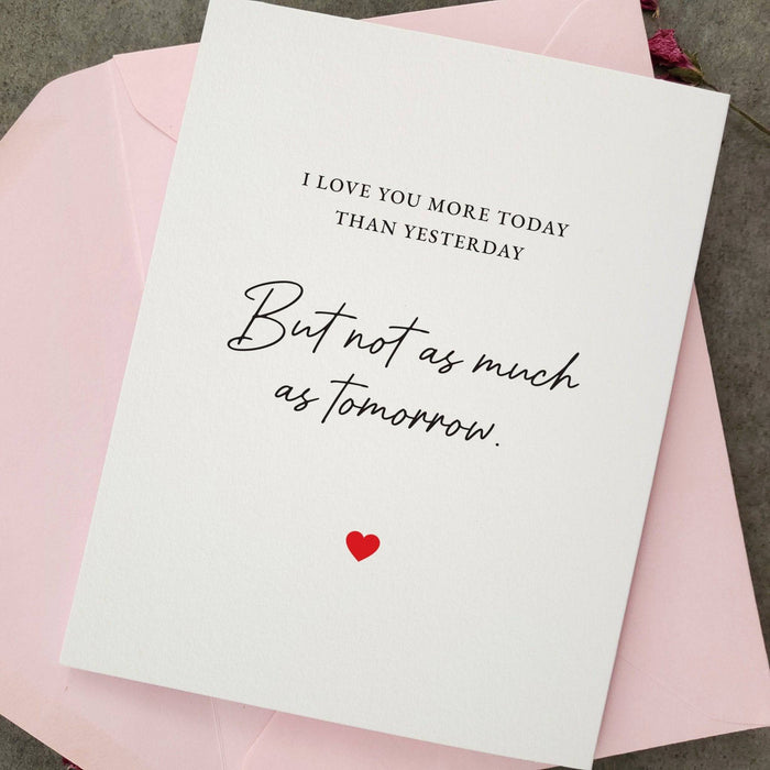 Greeting card styled with pink envelope, featuring romantic love quote in black script with red heart accent — XOXOKristen.
