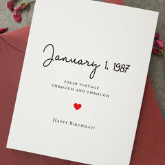 Standing birthday card displayed with burgundy envelope, featuring minimalist typography and custom date front design — XOXOKristen.