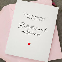Greeting card styled with pink envelope, featuring romantic love quote in black script with red heart accent — XOXOKristen.